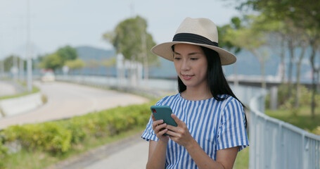 Woman search on cellphone of the location in city