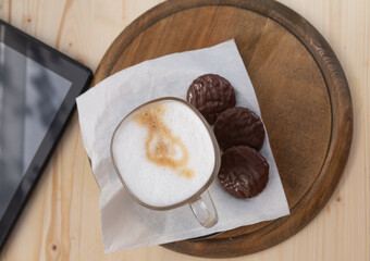 a cup of cappuccino and a mobile device