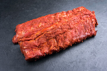 Rohe Spare Loin Ribs St Louis Style mit würzigen Rub angeboten als close-up auf schwarzen Hintergrund mit Textfreiraum