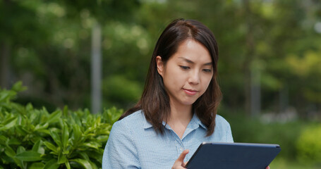 Fototapeta premium Woman look at tablet computer at outdoor