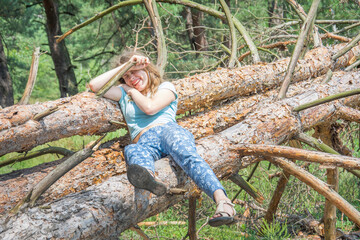 Naklejka na ściany i meble In the summer, in the forest, a girl fell from a tree.