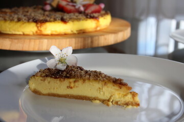 A piece of sweet cheese cake with flower decor.
