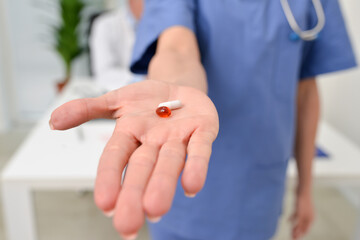 Smiling nurse showing a pill