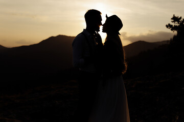 Wedding couple in the sunset. silhouette of groom and bride in mountains.