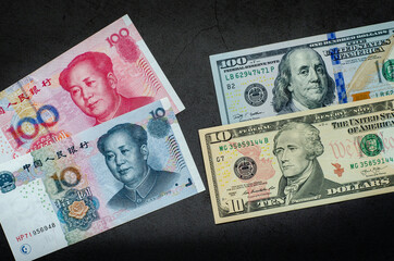 U.S. dollar (USD) vs Chinese Yuan (CNY) banknote concept.