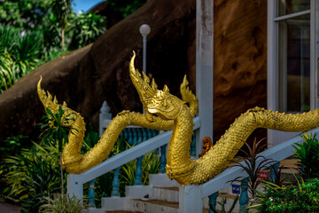 Blurred abstract background of sculptures seen at temples or religious tourist sites (Phaya Nak, Buddha statues) within Wat Pa Phu Kon in Udon Thani, Thailand