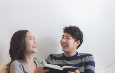 Young happy Asian couple smiling and laughing together at home