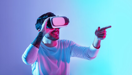 Wonderful sight. Smiling man in virtual glasses points his finger to side