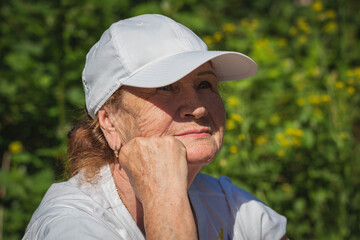 Portrait of an old woman on the background of the forest.