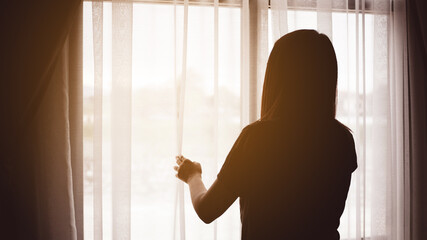 Thoughtful girl standing with looking at window, sad depressed teenager spending time alone at home, young upset pensive woman feeling lonely or frustrated thinking the problems