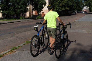 man with two bicycles on the city street