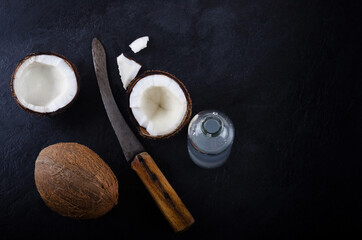 coconuts with knife and coconut water on dark background. How to make coconut water at home  