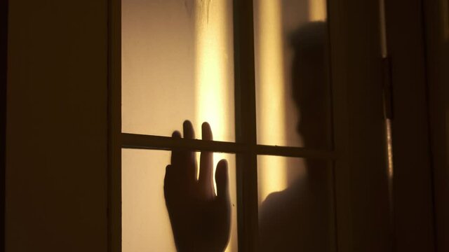 Silhouette of a sad teenager locked in a room