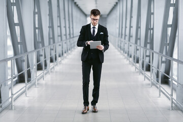 Obraz premium Focused urban business man holding digital tablet