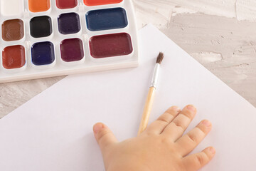 Cute little girl painting at home, distance education online. Top view