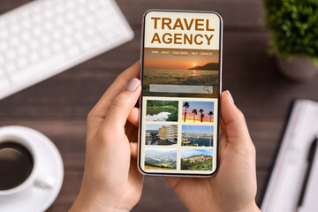 Unrecognizable Man Using Travel Agency Website On Smartphone While Sitting In Office