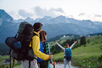 Group of happy friends with backpacks hiking together