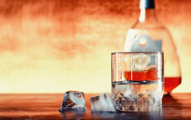 A glass of hard alcohol with ice on a bar counter. Whiskey with soda in a glass. Advertising...