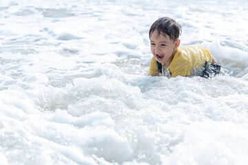 Portrait of little boy splashing in ocean waves