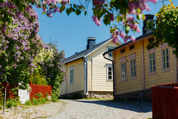 Beautiful street with old wooden houses and blooming lilac in old town of Porvoo