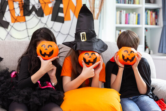 Happy Halloween by a group of children, brother and sister in carnival costume in decorated house