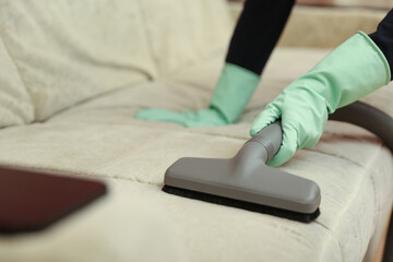 Fototapeta premium vacuuming furniture by vacuum cleaner close up