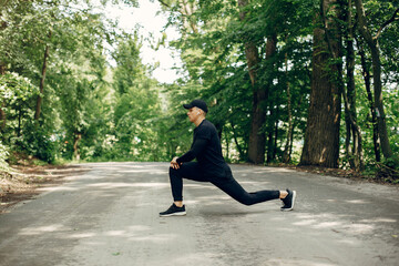 Handsome man in a park. Sportsman in a sportswear. Guy training