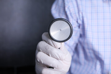 Close up of doctor hand using stethoscope.