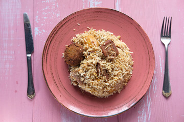 Lamb biryani meal in a bowl on table.