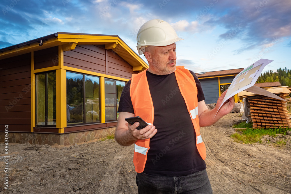 Poster man near a newly built cottage. man is dissatisfied with the built house. dissatisfaction with the w