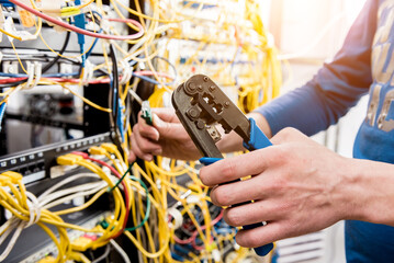 Network engineer working in server room. Connecting network cables to switches