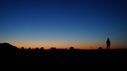 silhouette of a man watching in the sunset