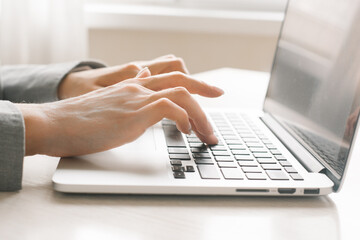 Close-Up Of Female Hands Typing Text On The Keyboard Of Laptop Or Computer.