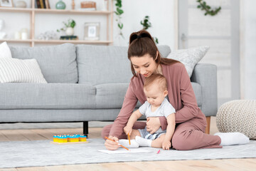 Activities For Toddlers. Mom And Her Toddler Son Drawing Together At Home