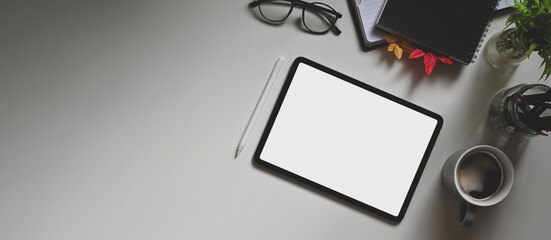 Blank screen computer tablet with a stylus pen is putting on a workspace.