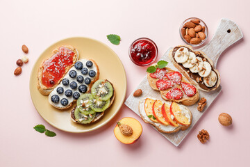 Sweet sandwiches with fruits and berries on pink colorful background.