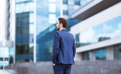 Successful businessman in downtown area of big city, back view