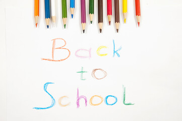 on a white background the inscription back to school and a set of colored pencils at the top of the image