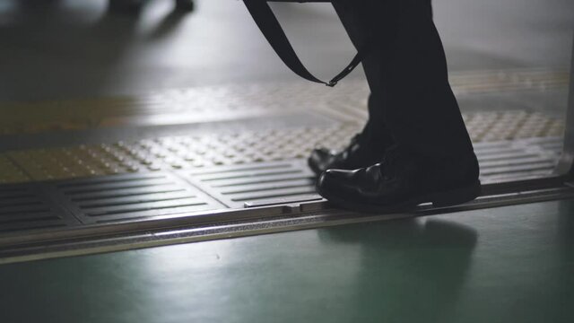 Feet Of A Japanese Businessman Stepping Out Of The Train At The Station In Tokyo, Japan - close up slowmo