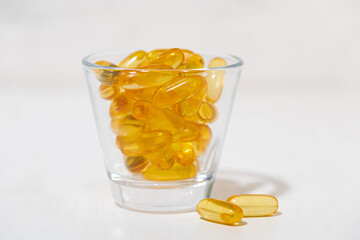 fish oil capsules in a glass
