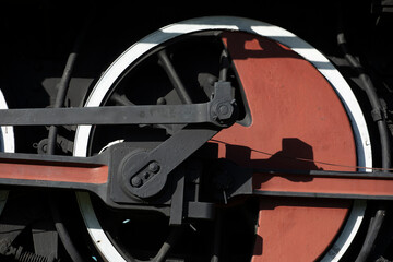 close up of an old steam locomotive wheel painted red with black and white trim