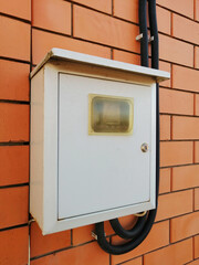 shield, electricity on the facade of a brick house. wiring
