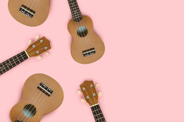 Composition made of ukulele on a pastel pink background with copy space. Hawaiian guitar pattern.