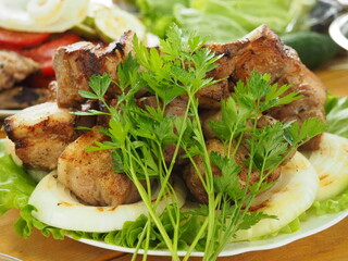 pork skewer with a bunch of fresh parsley on a plate. ready-made grilled meat.