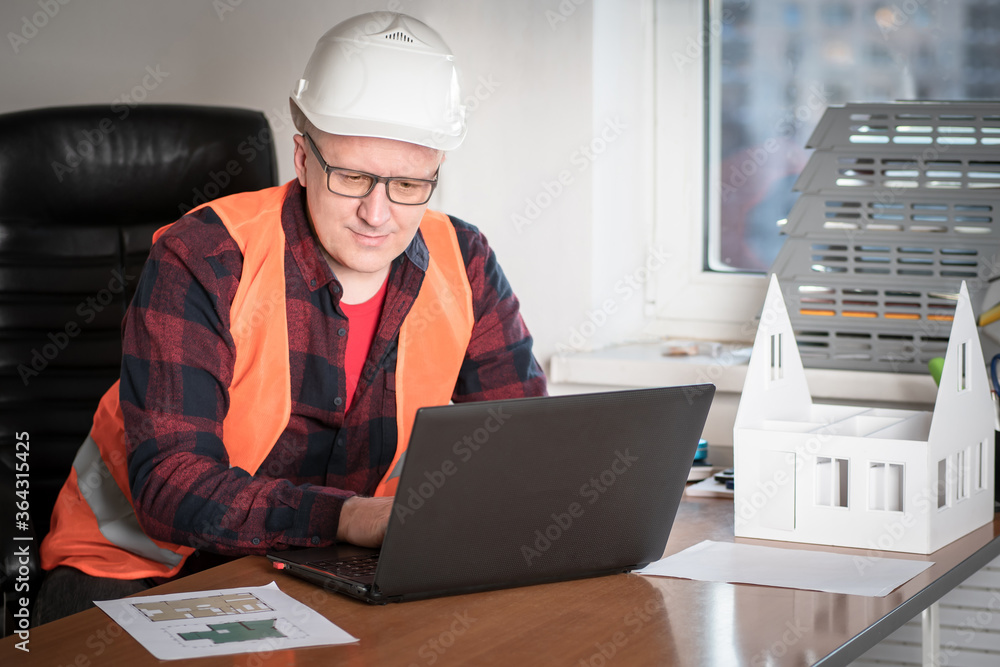 Poster an engineer is working on a laptop on a project for a new building. preparation of a construction pr