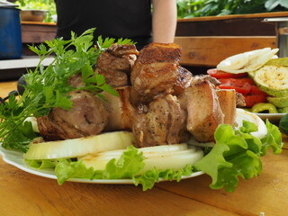 pork skewer with a bunch of fresh parsley on a plate. ready-made grilled meat.