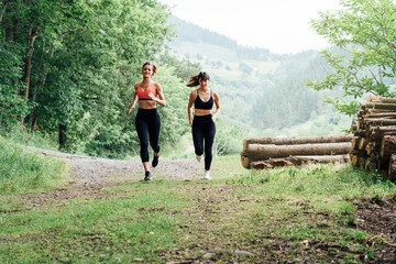 two girls running down a road through the woods