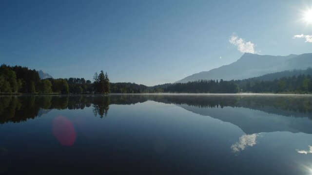 Idyllic Schwarzsee with bright sun reflecting light on its glassy lake surface