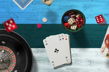 Estonia casino theme. Aces in poker game, cards and chips on red table with national flag...