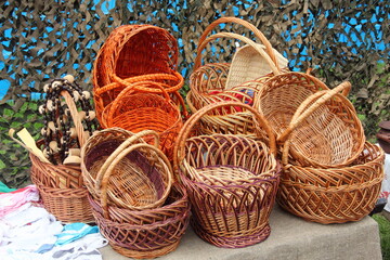 A lot handmade folk art wicker baskets at the fair, traditional Russian handmade products made of birch bark